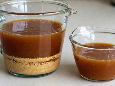 Amber browned butter cooling in a glass pyrex jug with toasted milk solids settled at the bottom